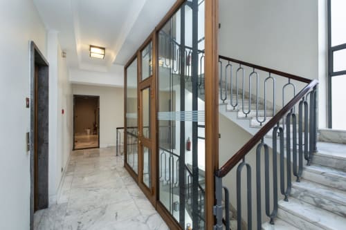 Moderner Flur mit Glastrennwand in Holzrahmen und Metallgeländer der Treppe in den Magnolia Apartments Mailand
