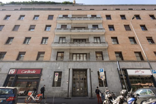 Fassade des Magnolia Apartments Mailand Gebäudes mit Erdgeschossläden einschließlich Cardinale Store und abgestellten Fahrrädern