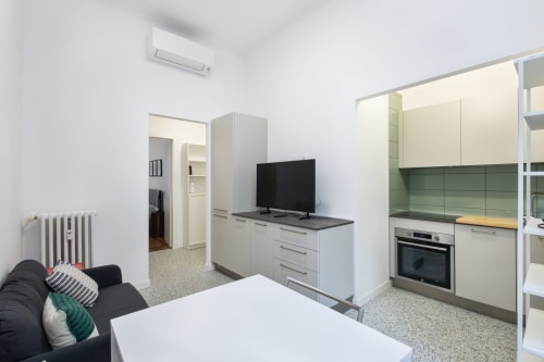 Moderno espacio de vida abierto en Magnolia Apartments Milan con cocina, comedor y sofá
