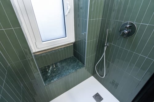 Moderno plato de ducha con azulejos verdes y alcachofa de lluvia en Magnolia Apartments Milan