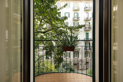 Vista desde el balcón de Magnolia Apartments Milán mostrando plantas en macetas, barandilla metálica y fachada histórica del edificio Porta Romana