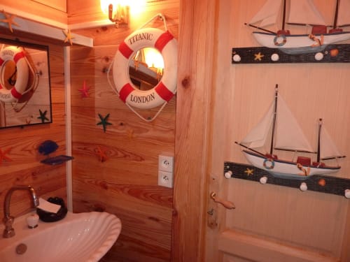 Salle de bain de la chambre Corsaire, décoration marine immersive avec bois naturel et objets marins, chambre d’hôtes insolite près d’Anduze