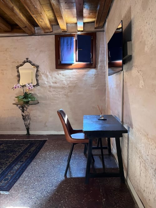 Stanza veneziana al Casanova Hideaway con scrivania, poltrona, specchio decorativo e travi in legno a vista