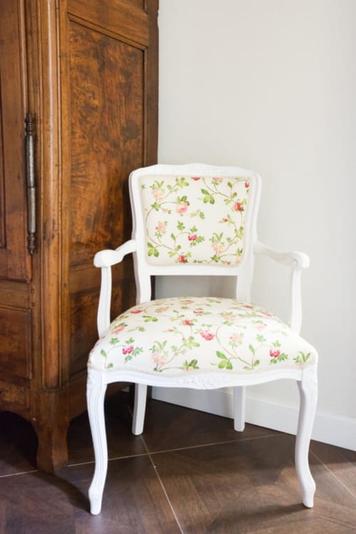 White armchair with floral upholstery beside wooden wardrobe in Alessia's Place Como apartment