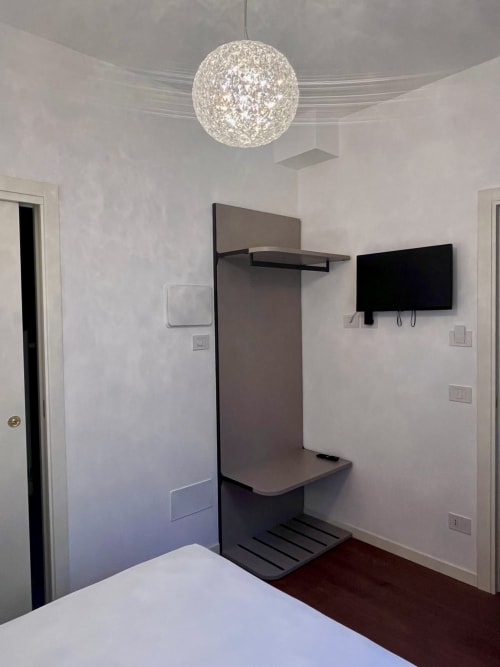 Modern Venice BnB room with wall-mounted TV, coat rack, and pendant light at Casanova Hideaway
