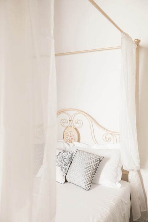 Elegante letto a baldacchino con drappeggi color crema e cuscini decorativi nella Suite 3 di Alessia's Place, Como