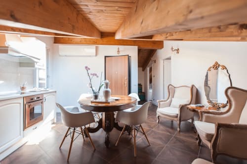 Area living della Suite 4 di Alessia's Place a Como con tavolo da pranzo, eleganti sedute e soffitto con travi in legno