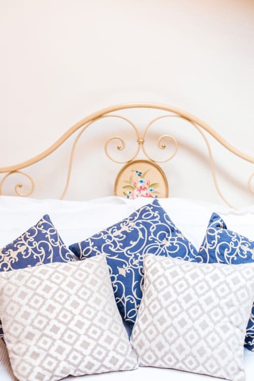 Elegant bed with ornate gold headboard and decorative pillows at Alessia's Place in Como