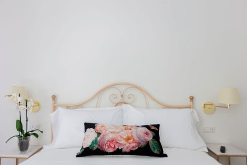 Elegantly styled bed with ornate headboard, white linens, and floral accent pillow at Alessia's Place B&B in Como