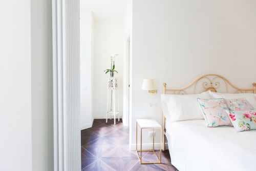 Bright bedroom at Alessia's Place Como with ornate bed, floral pillows, and access to terrace with garden view