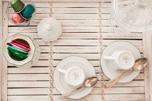 Overhead view of elegantly set table with white teacups, saucers, and cutlery at Alessia's Place Como B&B