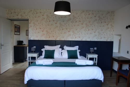 Elegant double bed in Chambre supérieure at Domaine des Piéris, Grandcamp-Maisy, with dark headboard, white linens, and