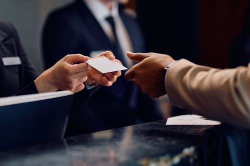 Des professionnels échangeant leurs cartes de visite à la réception de l'hôtel Conciergerie Saint Martin à Paris
