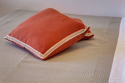 Red and cream decorative pillow on a beige textured bed at Palazzo Belvedere hotel in Chianciano Terme