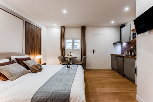 Luxury studio apartment in Bordeaux with bed, kitchenette, seating area, and flat-screen TV