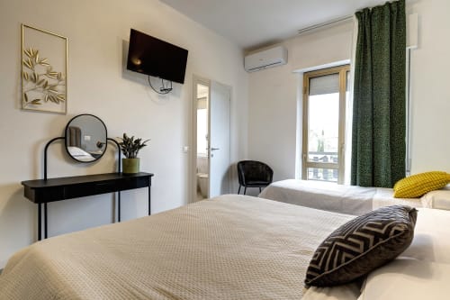 Modern hotel room at Palazzo Belvedere with twin beds, balcony, desk, and city views in Chianciano Terme