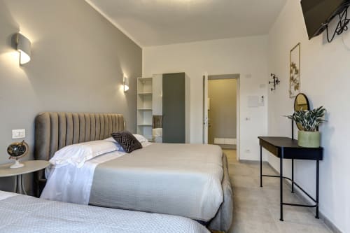 Modern bedroom at Palazzo Belvedere hotel in Chianciano Terme with striped headboard, desk, and ensuite bathroom