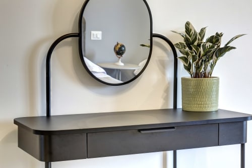 Modern black desk with round mirror and potted plant at Palazzo Belvedere hotel in Chianciano Terme