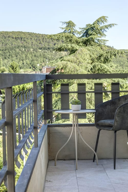 Balcony at Palazzo Belvedere with mountain views, table, chair, and lush forest landscape in Chianciano Terme