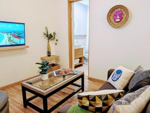 Sala de estar Casa Donceles en Ciudad de México con muebles modernos, televisor, plantas y máscara decorativa