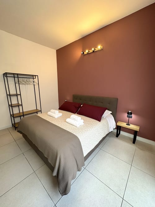 Camera moderna all'Hotel Le Arche di Verona con parete in terracotta, letto matrimoniale e arredi contemporanei