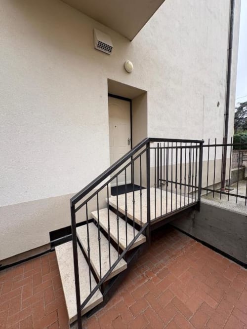 Scala moderna con ringhiera in metallo nero che conduce all'ingresso dell'appartamento presso l'hotel Le Arche di Verona