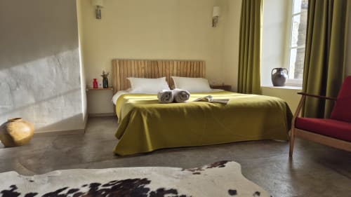 Saint André-slaapkamer in hotel Moulin Renaudiots in Autun, Frankrijk met geel-groene beddengoed, houten hoofdeinde en modern design