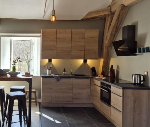 Moderne keuken in appartement L'Annexe du Moulin Renaudiots in Autun, met houten kasten en zwart werkblad