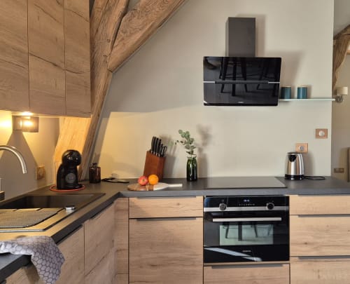 Moderne keuken in appartement L'Annexe du Moulin Renaudiots, Autun, met houten kasten en donkere werkbladen