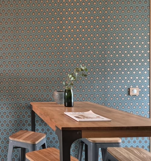 Modern eetgedeelte in Moulin Renaudiots met houten tafel, metalen krukken en geometrisch behang in Autun.