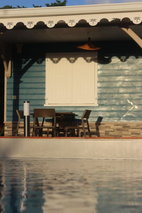 Terrasse en terre cuite avec piscine et transats face aux mornes verdoyants - Villa Bwa Kanpech Le Vauclin
