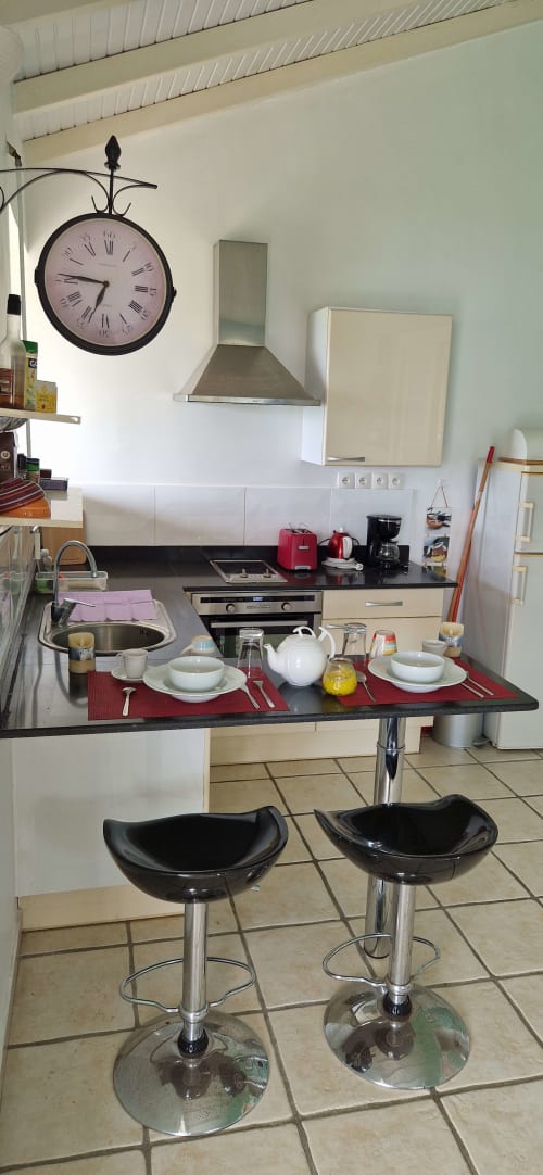 Table de petit-déjeuner élégante pour deux au gîte Le Nid De Bellemont à Trois-Rivières avec sets rouges et vue sur mer