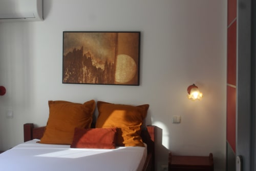 Chambre double climatisée et lumineuse avec décoration soignée aux tons chauds - Location Villa Martinique