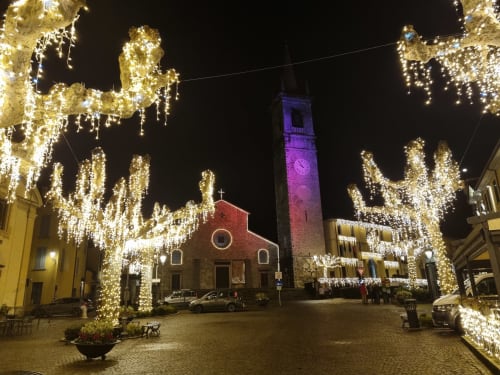 Bellano town square at night with holiday lights on trees, church and bell tower, Villa Vista Lago di Como nearby