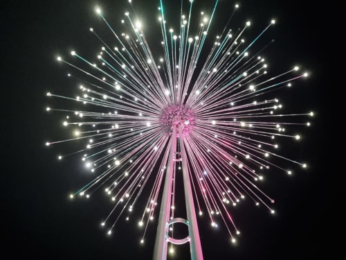 Pink illuminated Ferris wheel at night with radiant lights, Bellano, Como