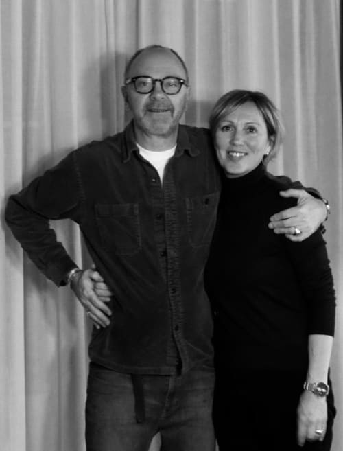 Two smiling guests posing together at Le Petit Château B&B in Baye, France, black and white portrait