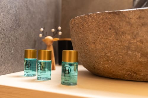 Produits de toilette haut de gamme et bol en liège dans la présentation des équipements de salle de bain d'un gîte saxon