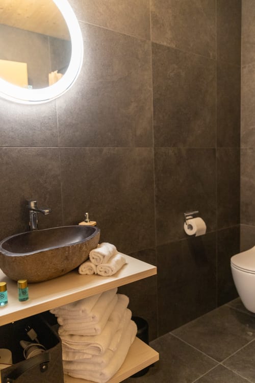 Salle de bain moderne du Chalet d'hôtes Les Louettes à Saxon avec vasque en pierre et sèche-serviettes électrique