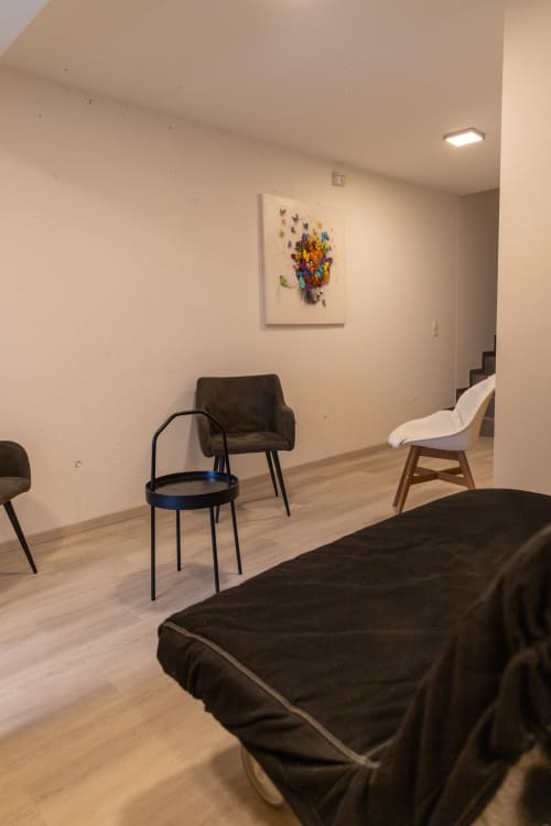 Chambre moderne du Chalet d'hôtes Les Louettes à Saxon avec lit noir, chaises contemporaines et œuvre papillons colorés