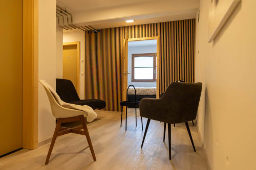 Salon cosy avec fauteuils modernes et parquet en bois au Chalet d'hôtes Les Louettes à Saxon, Suisse