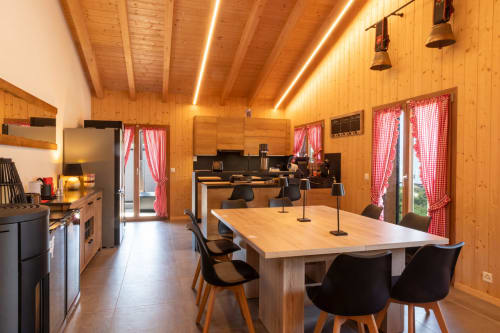Salle à manger et cuisine en bois moderne aux Louettes B&B à Saxon avec grande table, chaises noires et carreaux rouges