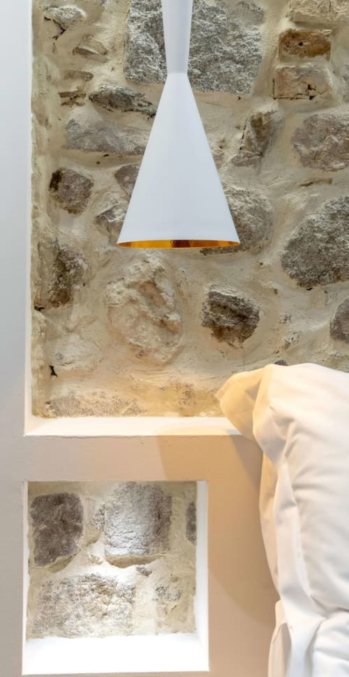 Muro in pietra rustica con lampada a sospensione conica moderna a Centro Da Viola Eco Design Rooms, Olbia