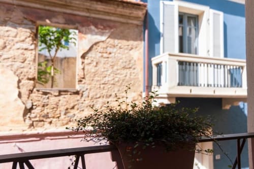 Terrazza del Centro Da Viola con piante in vaso che si affaccia sull'architettura storica in pietra di Olbia