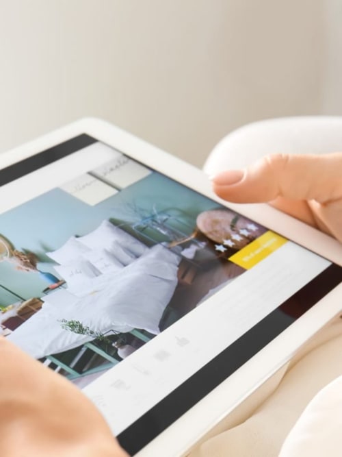 Main faisant défiler des photos sur une tablette à l'hôtel écologique Centro Da Viola à Olba