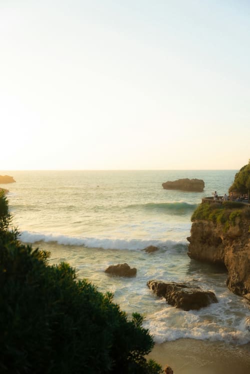 Vue du coucher de soleil sur la côte de Biarritz avec falaises rocheuses, vagues et horizon océanique à La Conciergerie