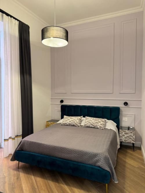 Camera moderna a Le Boutique del Centro di Napoli con letto rivestito in turchese, plafoniera e eleganti pannelli murali