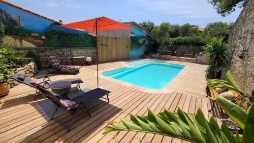 Espace piscine du Le N°9 BnB à Argeliers avec eau turquoise, terrasse en bois, transats et parasols pour des moments de détente et rafraichissent, clos et sans vis à vis.