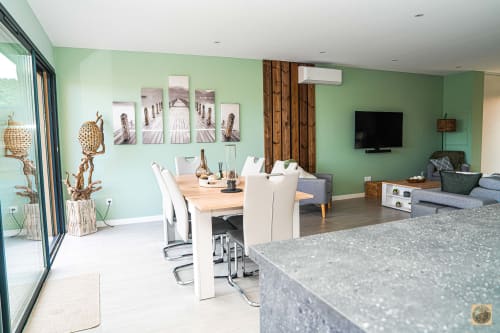 Villa moderne avec murs verts, salle à manger, salon et cuisine géré par la conciergerie Corsu di core