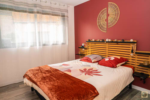 Chambre spacieuse à la Villa Core di Favona avec mur d'accent rouge et tête de lit en bois géré par la conciergerie Corsu Di core