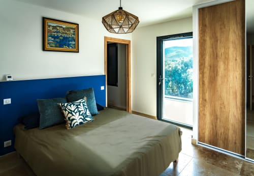 Chambre de villa moderne avec mur bleu, balcon vue montagne et décoration contemporaine à La Conciergerie du Cap Corse
